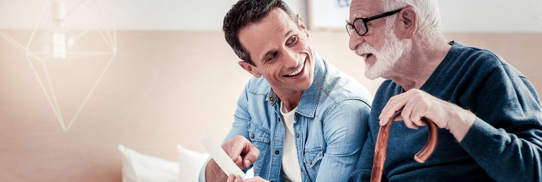 Old times. Positive delighted good looking father and son sitting together and discussing photos while remembering old times