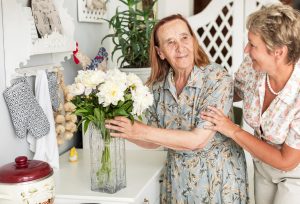 RESIZE senior-woman-holding-white-flower-vase-standing-near-her-daughter